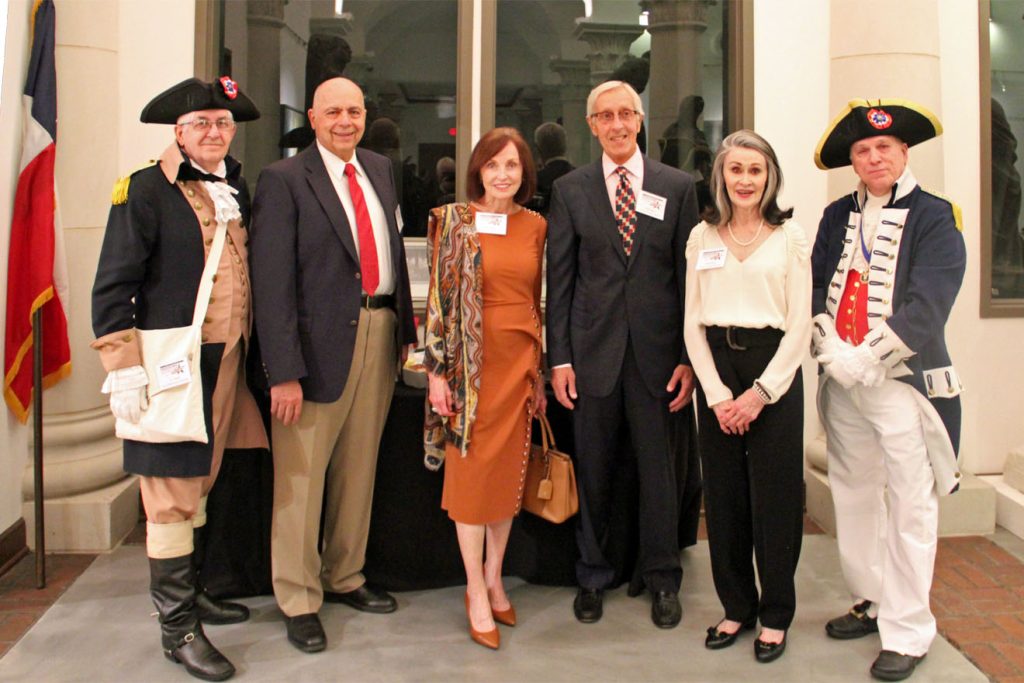 Adults with name tags standing next to adults dressed in historical costumes