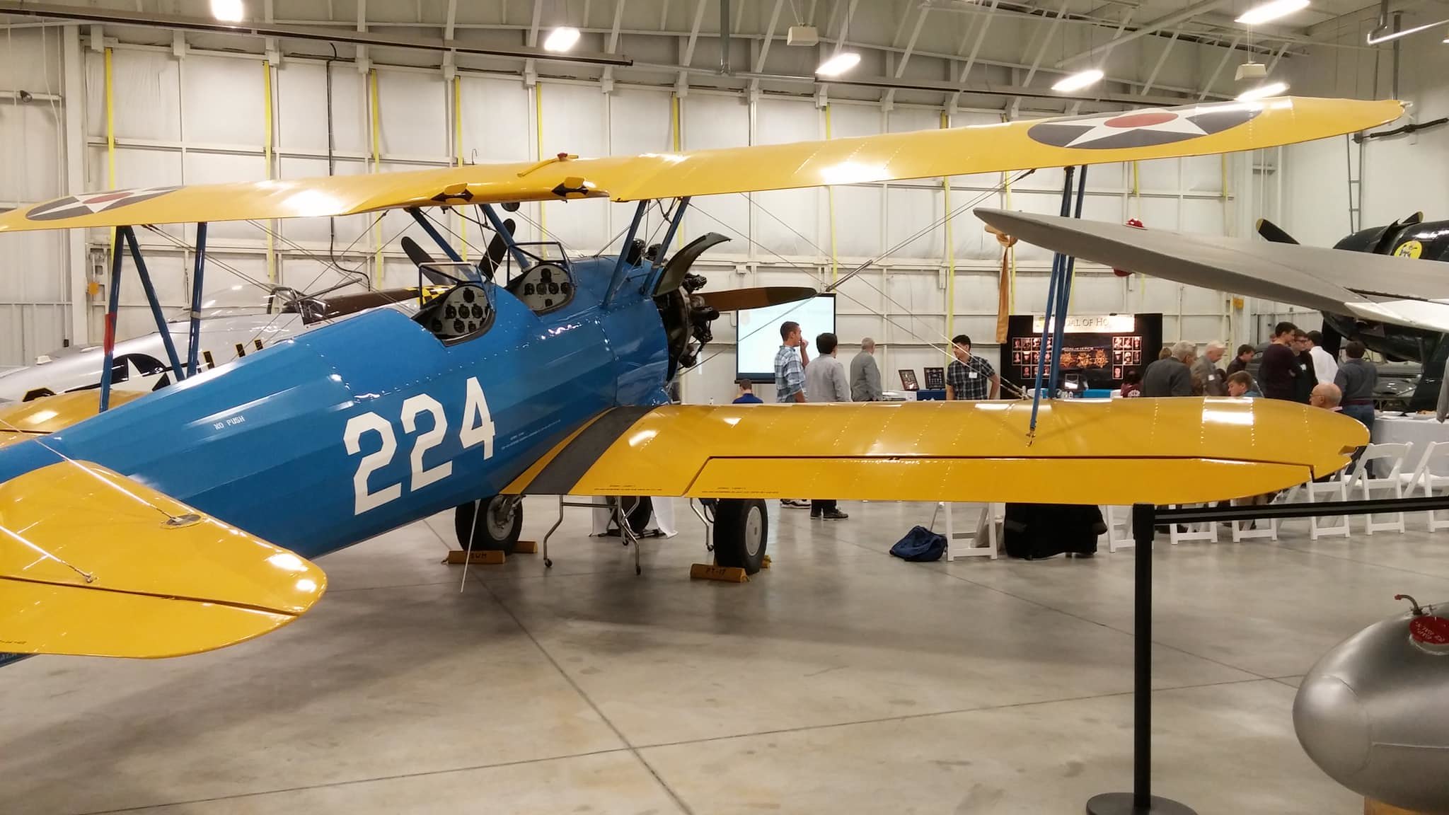 A group of students inside an airplane hanger for an event.