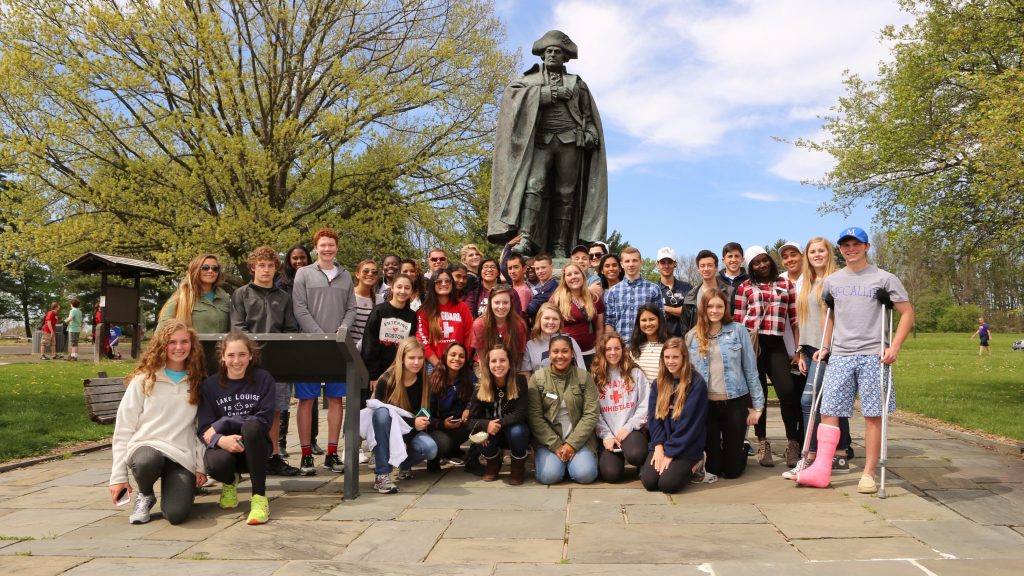 Group of high school students pose at a Valley Forge statue