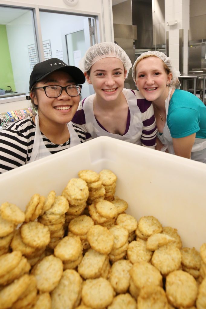 Students picture wearing hair nets with a box of tater tots in front