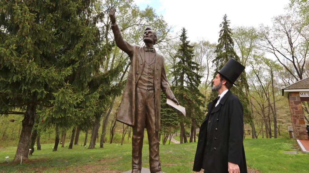 Lincoln Statue at the entrance of the Medal of Honor Grove with a Lincoln actor-historian looking up at the statue