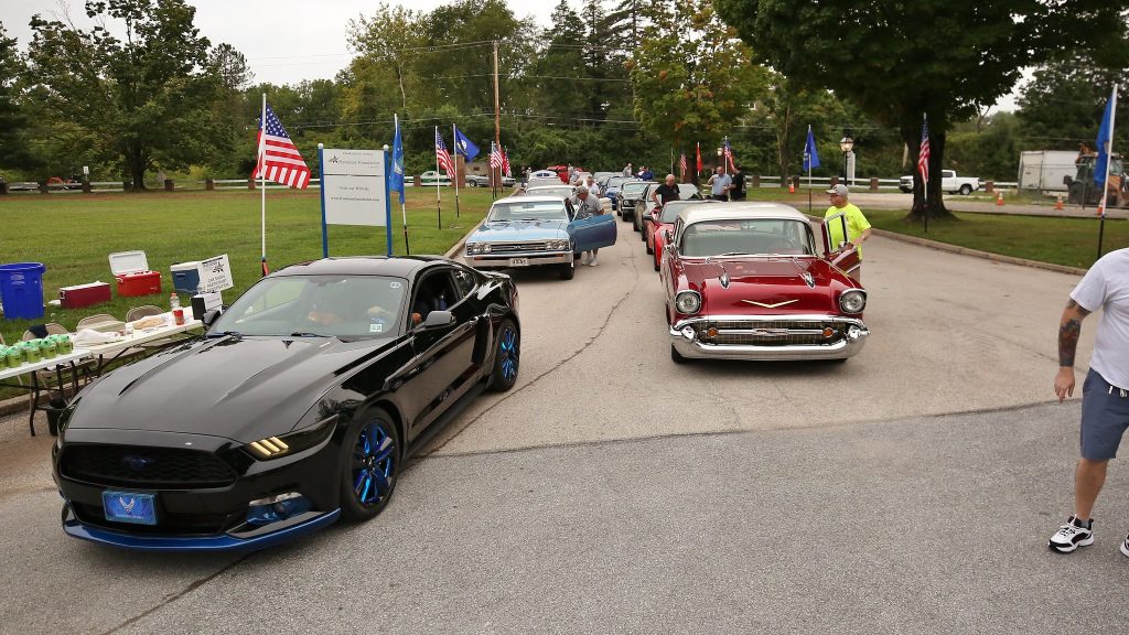 Line of cars in a car show in a parade at the Veteran's Car Show.